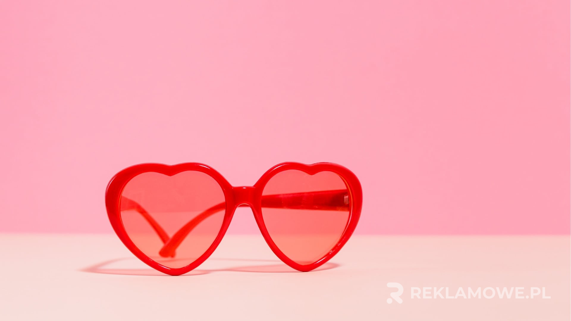 Okulary reklamowe na stole z zeszytami marketingowymi